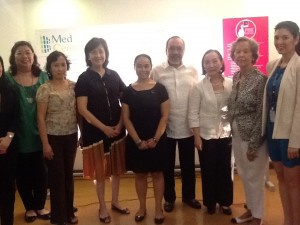 ICanServe volunteers and Med Central officials pose in front of the company's Pink Positive Pledge Wall. (September 26, 2013)